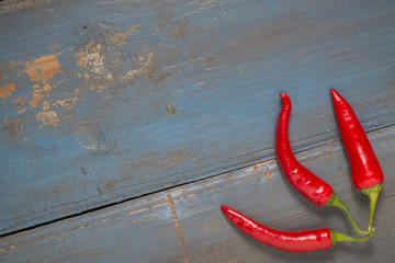 Red hot chilli peppers on a gray board table. Free space for text. Top view