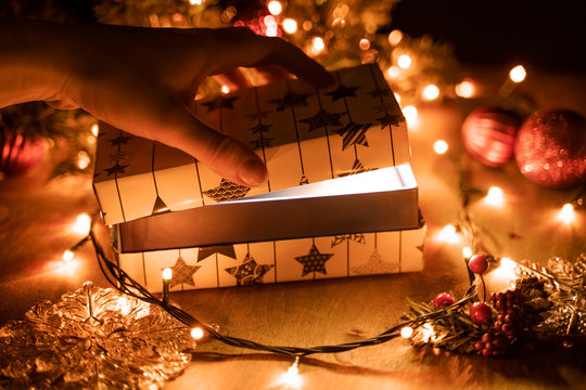 Hand Hold And Open A Mysterious Box On Wooden Table