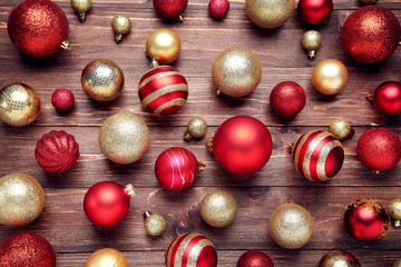 Red and golden christmas baubles on wooden table