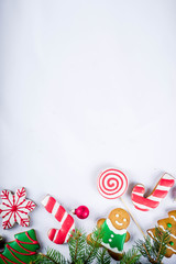 Various traditional colorful sugar glazed christmas gingerbread cookies, on white background top view copy space banner with xmas decorations