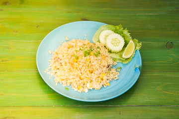 Fried rice with crab meat in dishes put on the green table.
