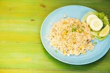 Fried rice with crab meat in dishes put on the green table.