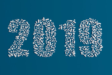 Background of a variety of tablets scattered on a blue background in the form of a silhouette text 2019 3d illustration