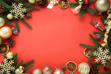 Christmas decorations with cones and orange fruits on red background