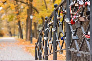 Romantic bridge with locks of people in love in autumn park
