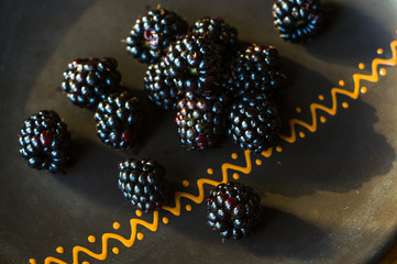 large juicy blackberry berries on a ceramic plate