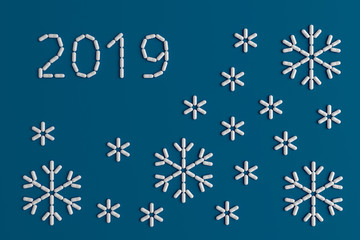 Background of a variety of tablets scattered on a blue background in the form of a silhouette figures 2019 and snowflakes 3d illustration