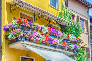 Picturesque balcony with flowers in a small town in Italy