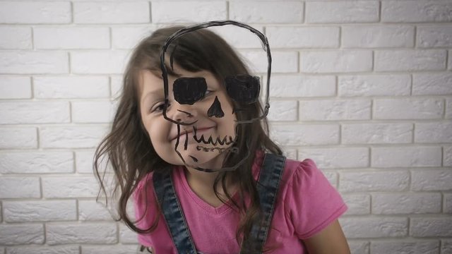 Halloween. Figure skull. Skull on the glass. A child with plays with a drawn skull.