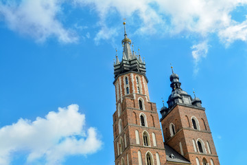Fototapeta premium Towers of the St. Mary's Church against the background of blue sky, Krakow, Poland. two towers of St. Mary's Basilica on main market sguare