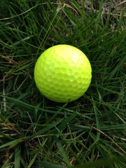 Gelber Golfball liegt im Gras , Nahaufnahme