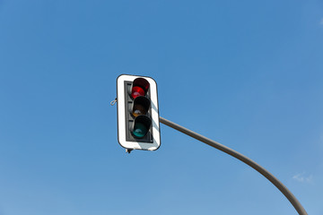 Red traffic lights against blue sky.
