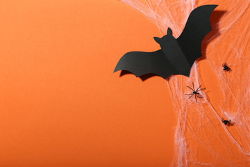 Halloween paper bats with cobweb and spiders on orange background