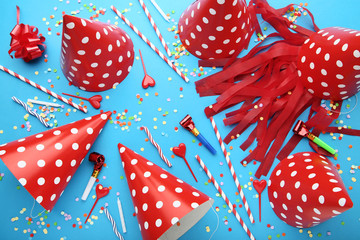 Birthday paper caps with straws, candles and blowers on blue background
