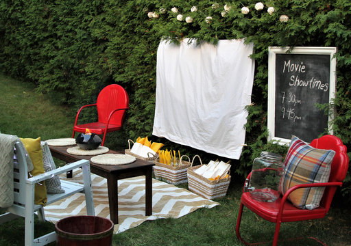 White sheet ready for a movie night outdoors with food and chairs