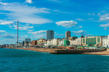 Fototapeta premium Beautiful view of Brighton Pier with Brighton beach sea, sand and British Airways i360 in the background. Popular landmark of the city.