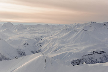 Landscape of pure winter mountains covered with snow under the sky with sun rays