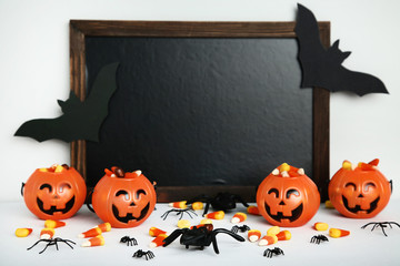 Pumpkin buckets with candy corns and black frame on grey background