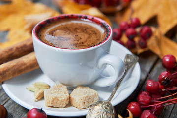 Hot steaming cup of coffee. Autumn fall leaves.