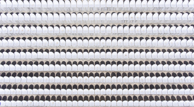 Aerial view empty white plastic chairs in a row at the football stadium.