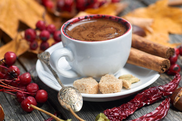 A cup of coffee with chili. Hot steaming cup of coffee. Autumn fall leaves.