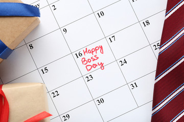 Inscription Happy Boss Day in calendar with gift boxes