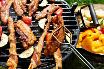 Meat and vegetables during grilling. Assorted types of bacon
