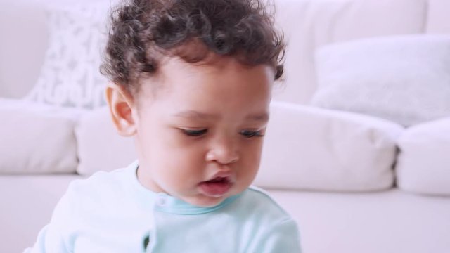 Black toddler playing xylophone in sitting room