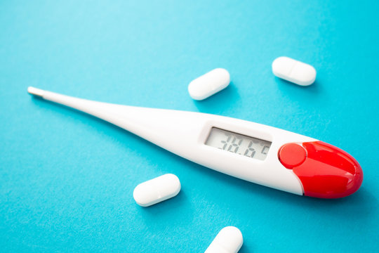 White Digital Clinical Thermometer Shows Fever Heat Temperature And Pills On Blue Background Stock Photo Adobe Stock