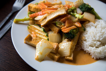 Vegetarisch rotes Thai Tofu Gemüse Curry aus Wok mit Reis im Restaurant