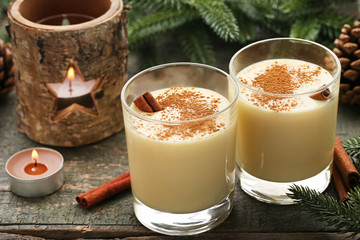 Eggnog in glasses with cinamon on wooden table