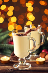 Eggnog in glasses with cinamon and star anise on lights background