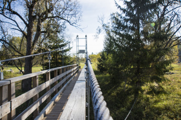 Suspension bridge on a rope on the background of the autumn landscape.