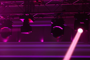 Light projectors at night party, pink light stream