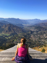 girl sitting looking at the view in the mountains