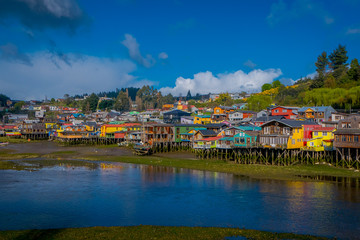 Outdoor view of colorful houses on stilts palafitos in the horizont located in Castro, Chiloe Island