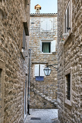 Old stone houses with windows with shutters in Budva in Monteneg
