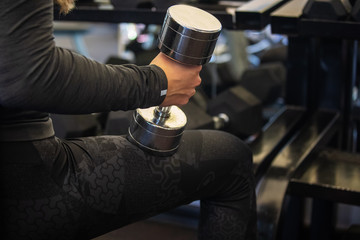 Young woman exercises with dumbbell