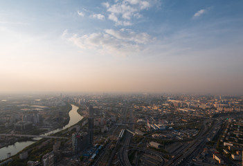Fototapeta na wymiar Aerial top view of Moscow city panorama at sunset, river and bridges, roads and buildings in evening myst