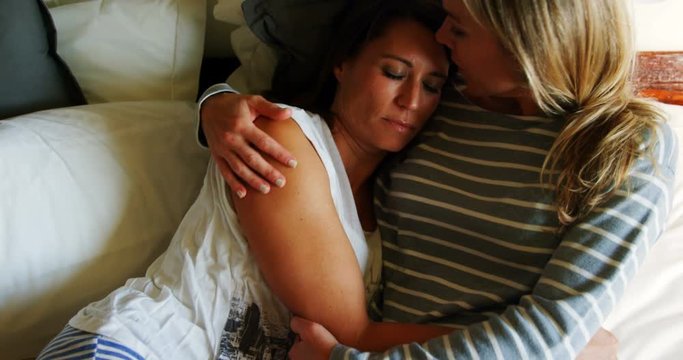 Lesbian couple relaxing on bed in bedroom 4k