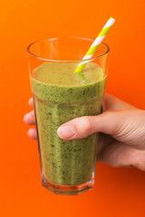 Fresh spinach and avocado smoothie in tumbler with paper straw