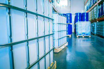 Chemical production. Plastic containers in stock. Warehouse chemicals. Blue barrels and white...