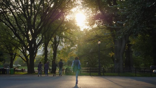 A slow motion view of people walking on The Mall in Central Park at sunset. Shot at 60fps.  	