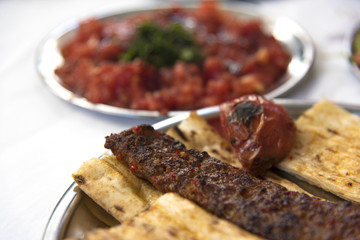 Traditional Adana kebab serving with salads in Turkey
