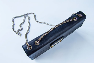 Black textured leather woman handbag with chrome chain furniture at white background. Top view. High resolution
