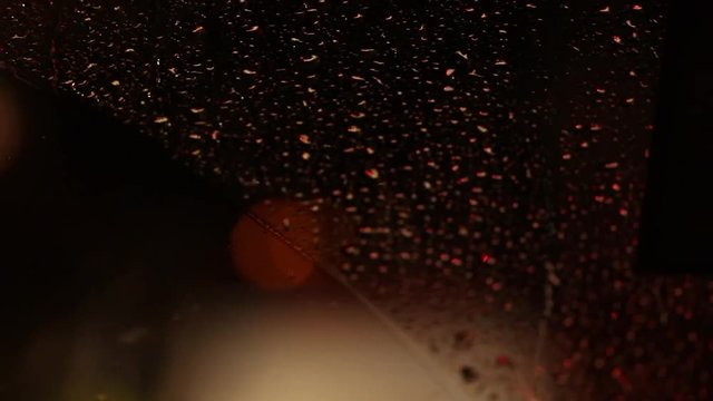 Emergency lights flashing seen behind windshield during rainy night3