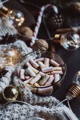 Christmas flat lay. Chocolate or cocoa with marshmallow, cookies, candy and the garland on a dark background. 