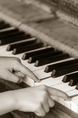 Fototapeta premium Little girl playing on the piano