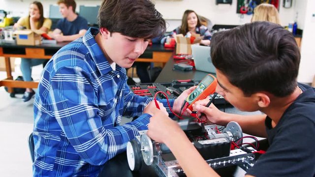 Male High School Pupils Building Robotic Vehicle In Science Lesson
