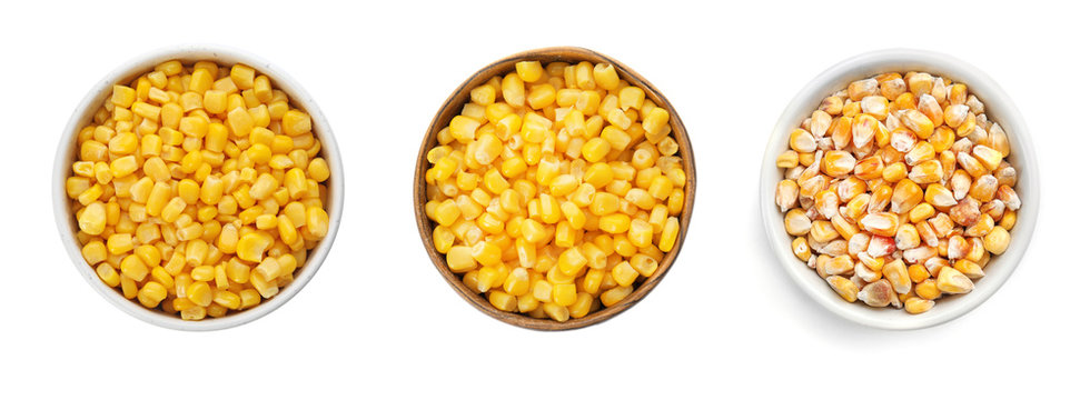 Set with bowls of sweet corn kernels on white background